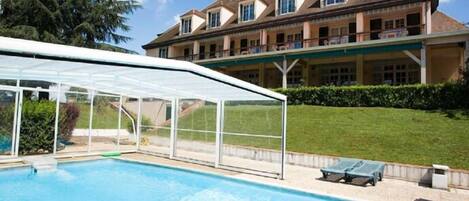 Una piscina techada, una piscina al aire libre de temporada, sombrillas