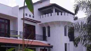 A two-story building with a white facade, a red roof, and a balcony. - Kamatha Hotel & Restaurant (Ambalantota)