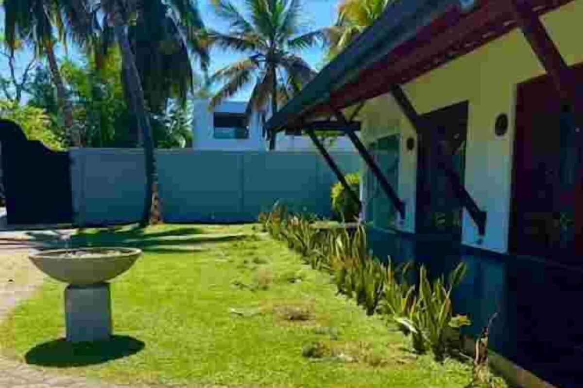 A courtyard with a fountain, palm trees, and a building with a red roof.