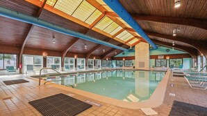 An indoor swimming pool with a wooden ceiling and large windows. - The Salty Mint - Resort Condo w/ Pools, Hot Tub, & Beach Access – Sleeps 7 (Kure Beach)