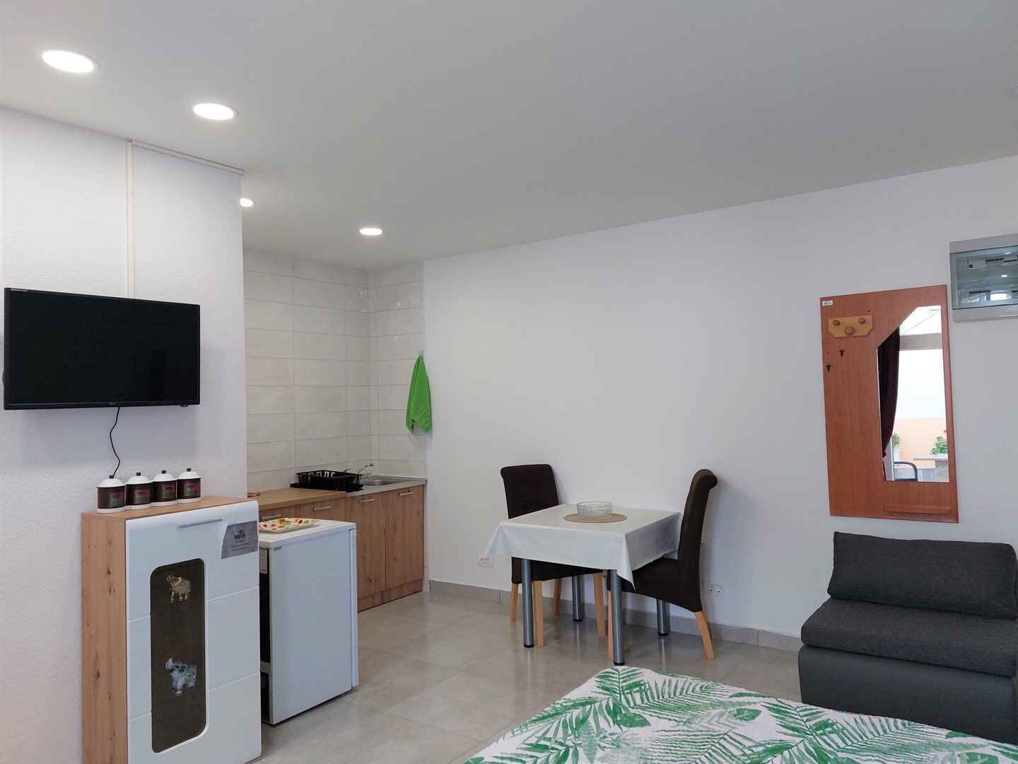 Um espaço compacto com cozinha americana, área de jantar e espaço para relaxar.