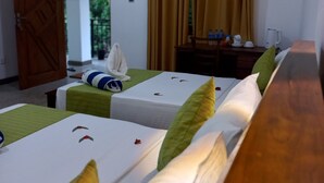A hotel room with two single beds, a wooden desk with a chair, a small table with a cup and saucer, and a window with curtains. - Wild Safari Nest Udawalawe  (Udawalawe)