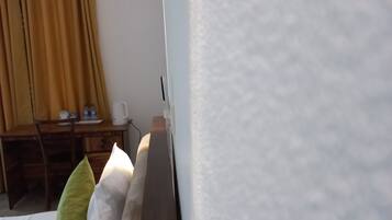 Una habitación con una cama, un escritorio y una silla.
