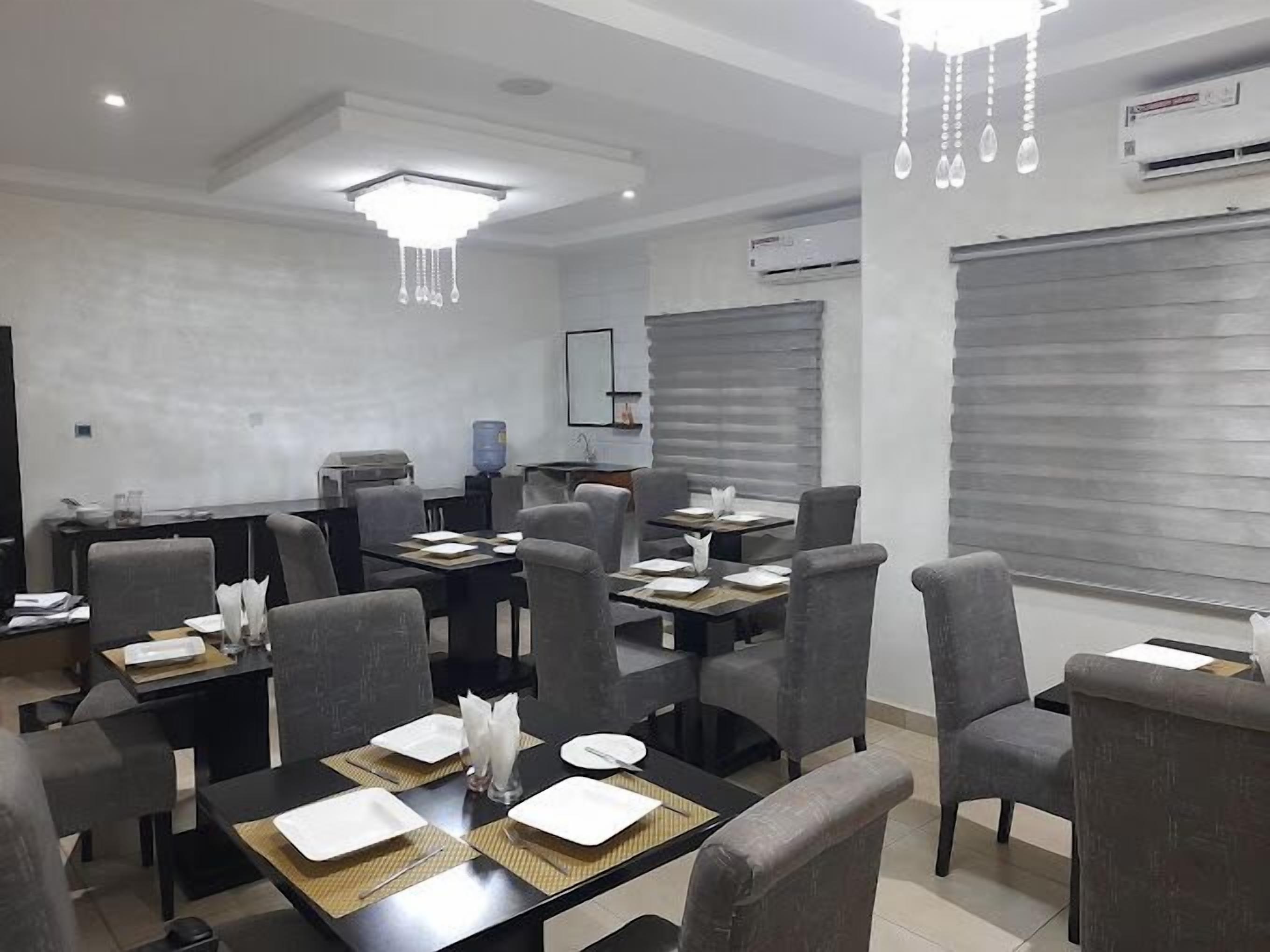 A conference room with tables set for meetings, equipped with chairs, a water dispenser, and a projector.