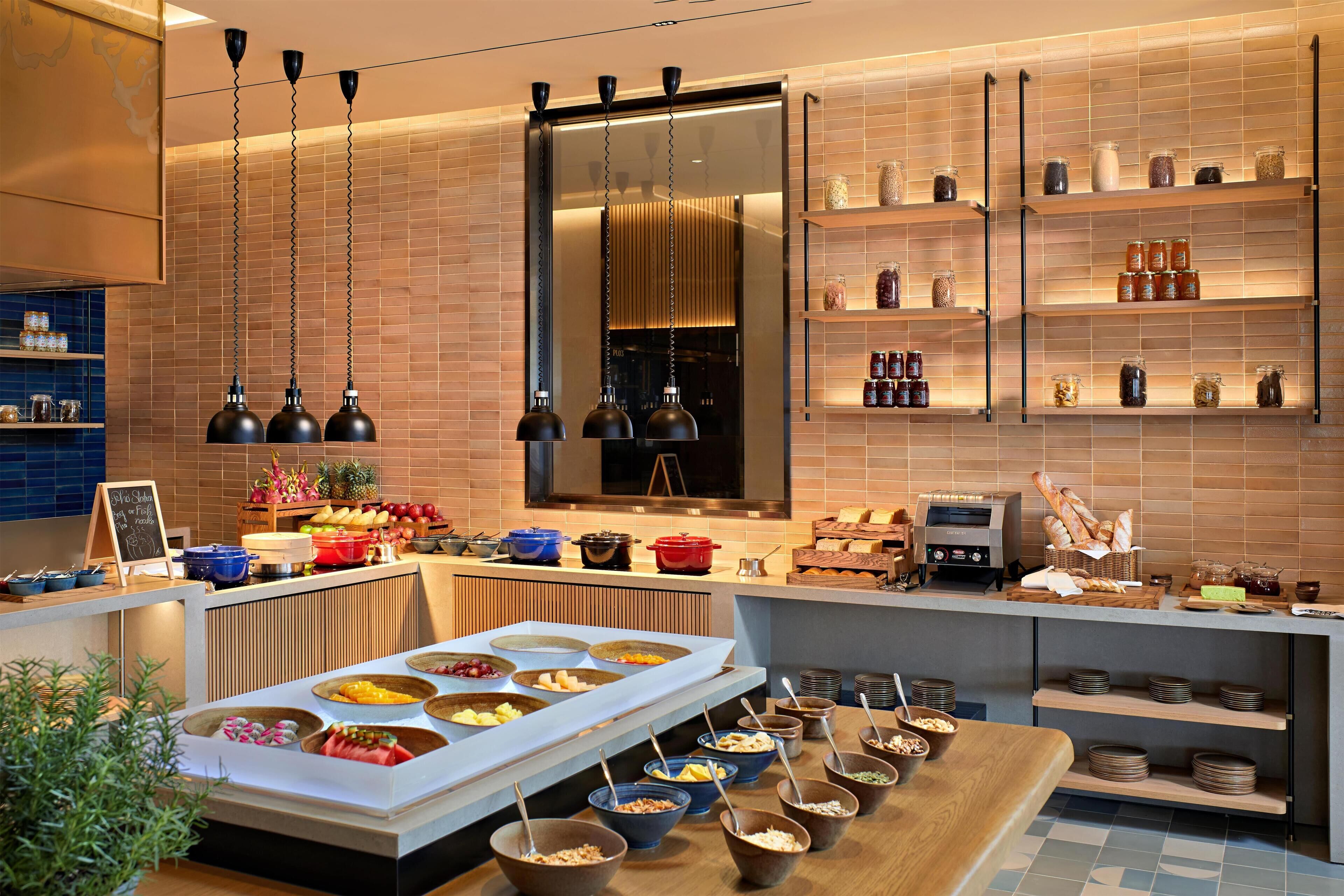 A modern kitchen with a buffet setup, including a variety of food items and utensils.