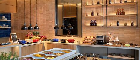 A modern kitchen with a buffet setup, including a variety of food items and utensils.