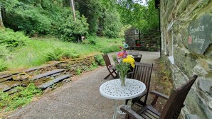 Un mur de pierres rustiques sur lequel est accrochée une pancarte indiquant « Snowdon Cottage ».