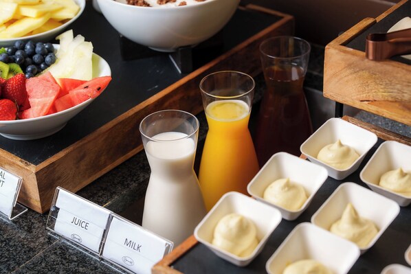A breakfast buffet with various fruits, milk, and juice options. - Honest Budapest by Chic & Basic (Budapest)