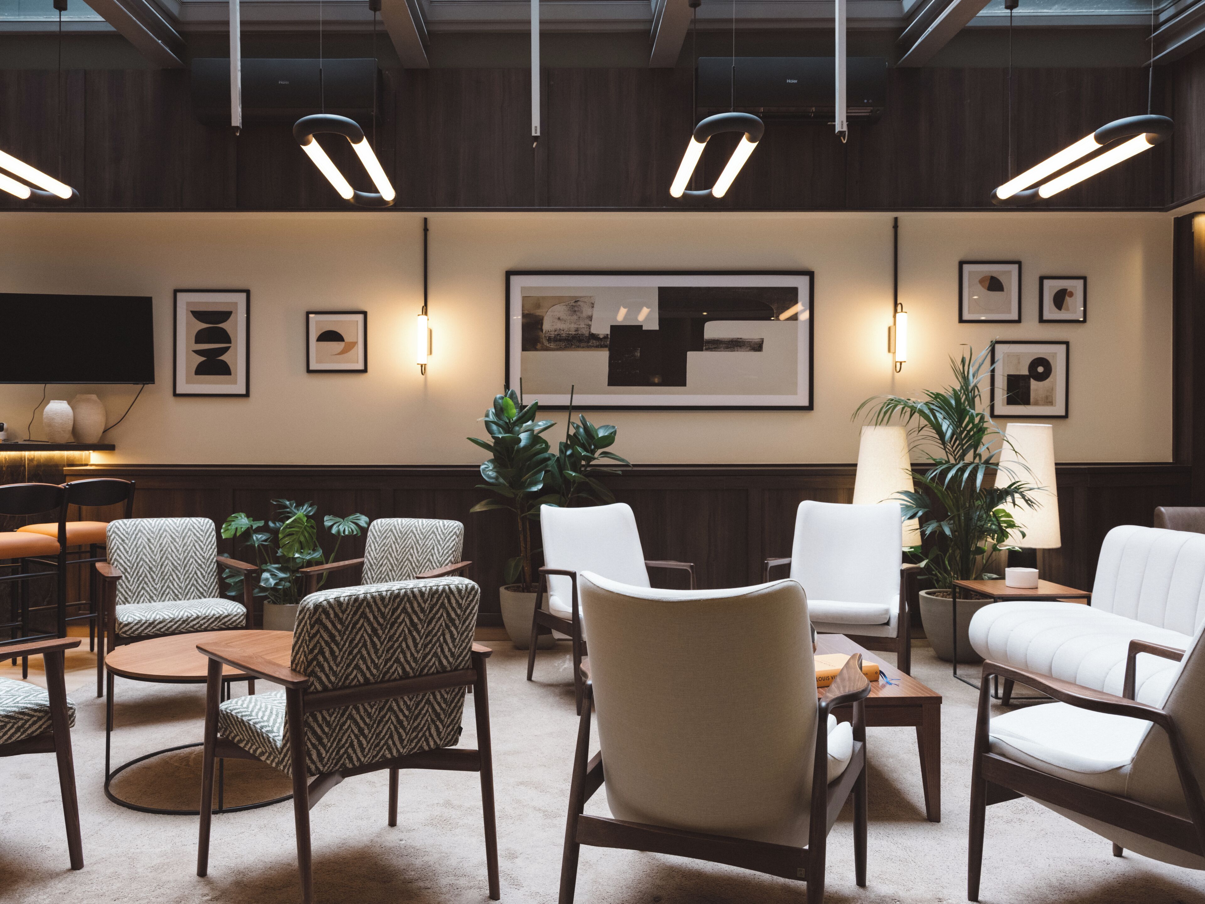 A modern lounge area with multiple seating options, including chairs and sofas, arranged around a central table.