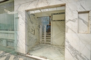 A marble-floored entrance with a glass door and a metal staircase leading inside. - Modern Comfort Stays at Swarop Nagar Kanpur (Kanpur)