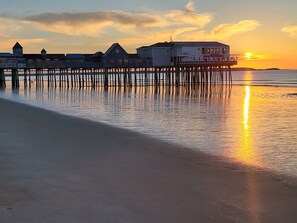 A pier extending into calm waters with buildings on stilts.