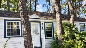 A white house with blue trim, a front door, and a small porch with steps.