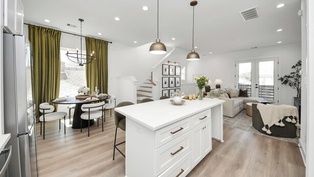 A modern kitchen with white cabinetry, a central island, and pendant lighting.
