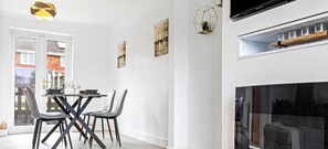 A dining area with a table and chairs, a pendant light, and artwork on the walls.