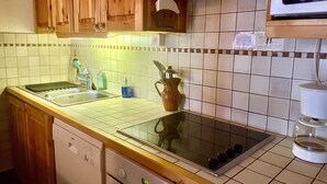 A kitchen with wooden cabinets, a dishwasher, a stove, and a microwave.