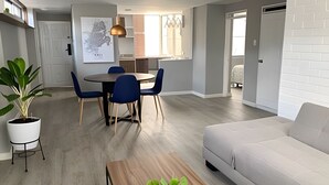 A modern living room with a sofa, a coffee table, and a dining area with a table and chairs. - Willis (Cali)