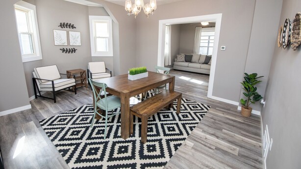 A dining area with a wooden table, chairs, and a patterned rug. - Two Bedroom Home close to Downtown and Hospitals (Sioux Falls)