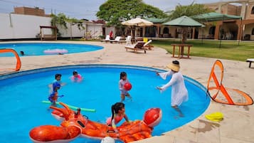 A swimming pool with inflatable toys and lounge chairs.