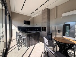 Una cocina moderna con una isla central, electrodomésticos de acero inoxidable y un comedor con sillas y mesa.