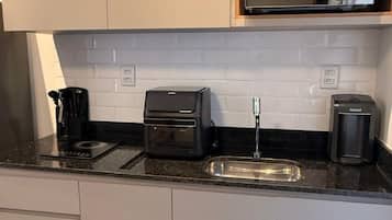 A modern kitchen with a microwave, toaster, and coffee maker on the countertop.