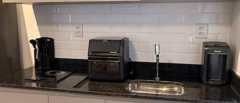 A modern kitchen with a microwave, toaster, and coffee maker on the countertop.