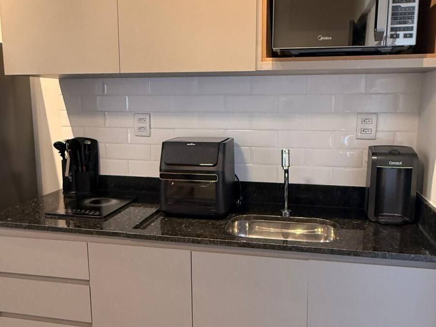 Une cuisine moderne équipée d’un four à micro-ondes, d’un grille-pain et d’une machine à café, le tout posé sur le plan de travail.