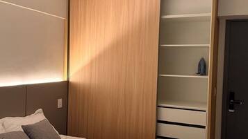 Un dormitorio con cama, armario con espejo y puerta.