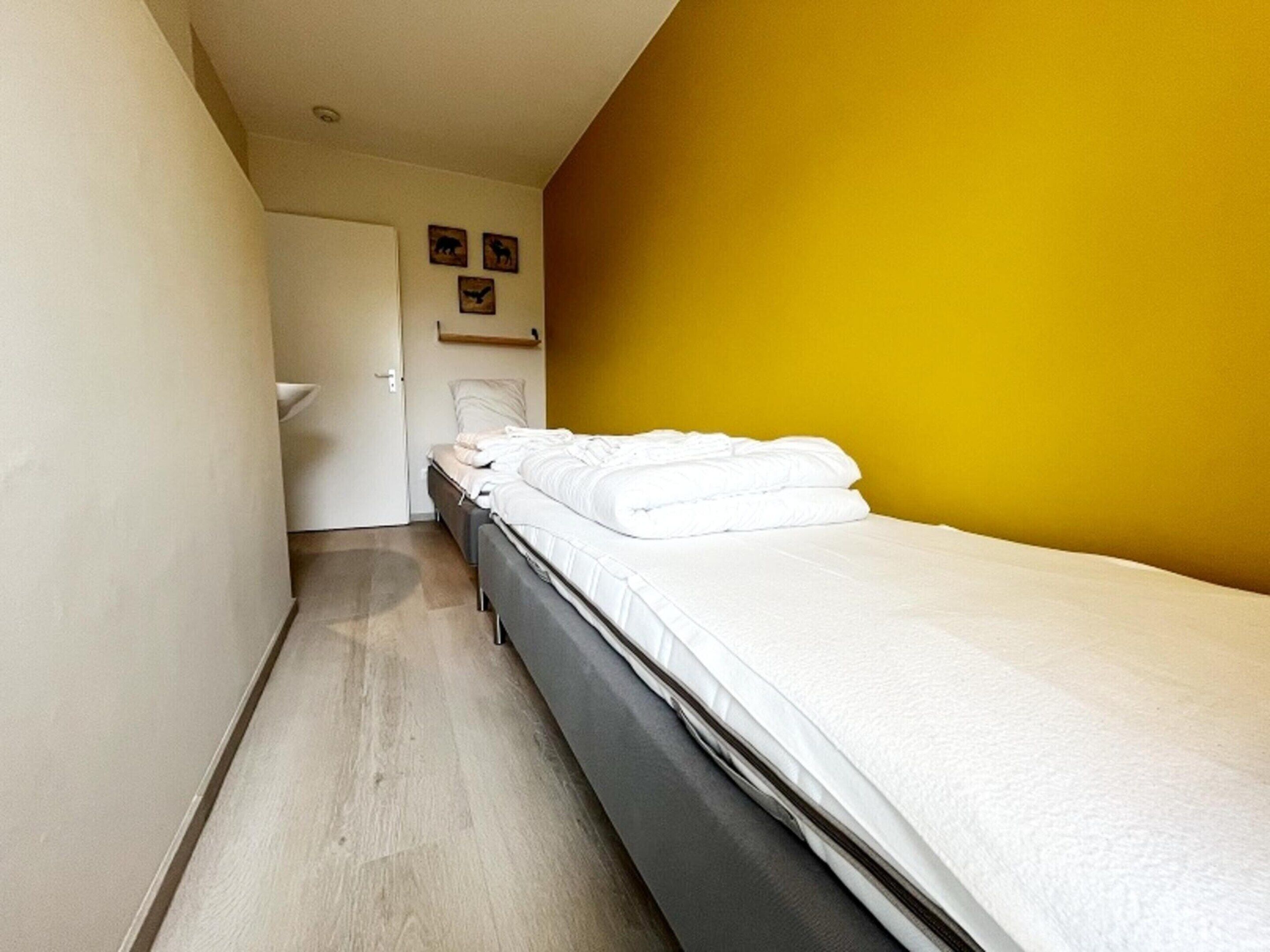 A room with a bed, a door, and a wall with animal prints.