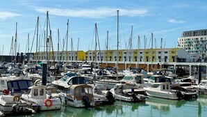 A marina with numerous boats docked, a building with balconies, and a clear sky. - On the Water 6  A One-of-a-Kind Stay | Free Parking | By My Getaways (Brighton)