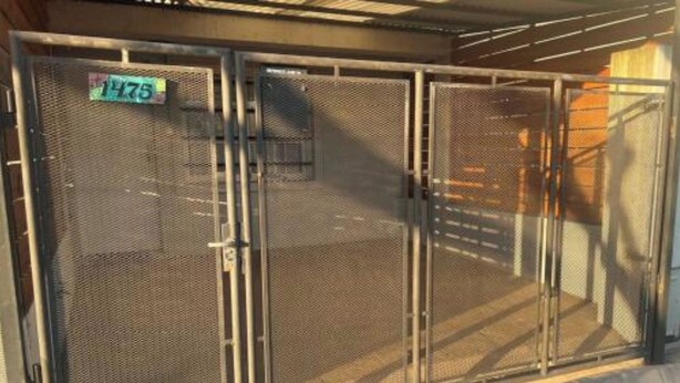 Een metalen hek met een nummerplaat.