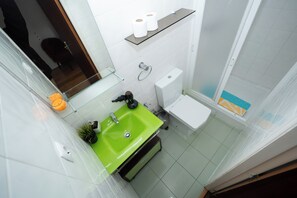 A bathroom with a green sink, white toilet, and a shower area. - Room-palma 1 Bedroom Apartment Lisbon (Lisbon)