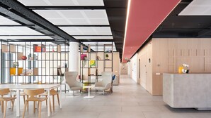 A modern office space with a reception desk, open seating area with chairs and tables, and a variety of books and decorative items on shelves. - aparto Milan Durando (Milan)