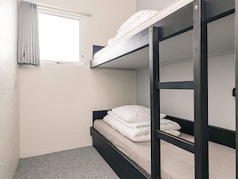 Habitación con literas, ventana y cortina.