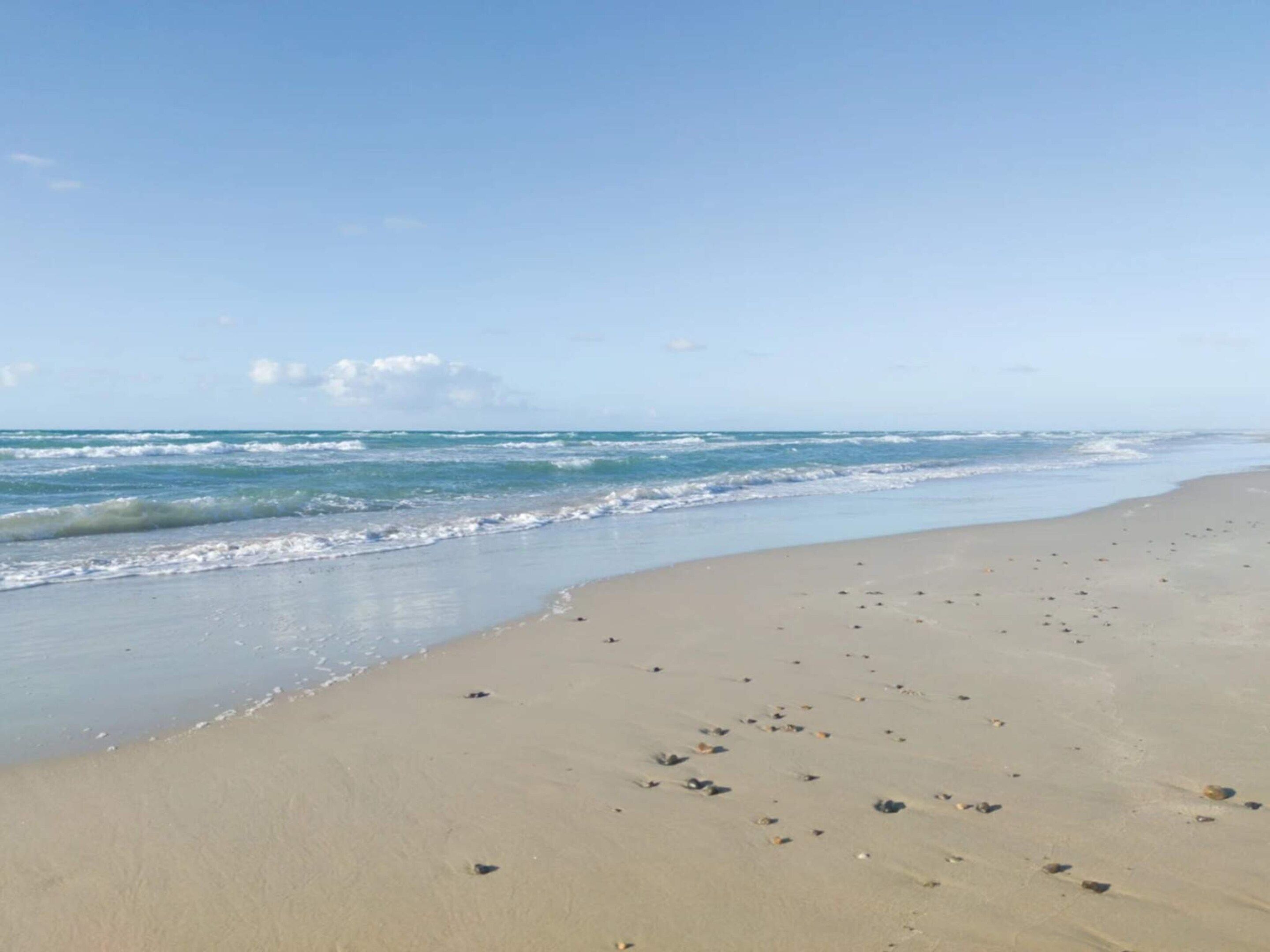 Una platja amb sorra i onades.