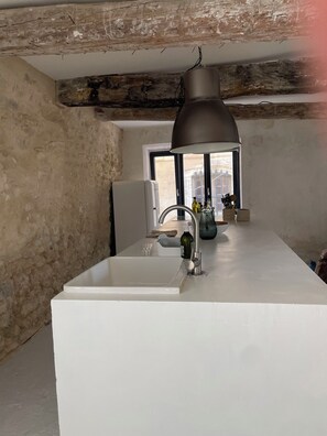 A kitchen with a white countertop, a sink, and a window with a view. - Gordes, in the heart of the village with private pool and panoramic view (Gordes)