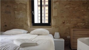 Une chambre à coucher avec un lit, une table de chevet et une commode en bois.