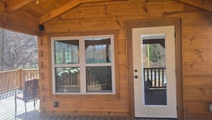 Une cabane en bois avec une grande fenêtre et une porte.