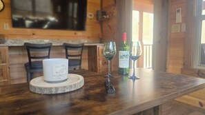 Ein Holzinterieur mit einem Marmortisch, zwei Weingläsern und einer Kerze.