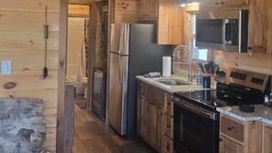 Une cuisine compacte avec des meubles en bois, un réfrigérateur en acier inoxydable, un four à micro-ondes et un lave-vaisselle.