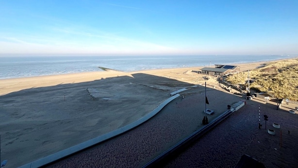 A beach with a clear view of the ocean, a sandy area, and a building with a flat roof. - Apartment in Wenduine With Stunning Sea View (De Haan)