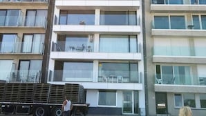 A multi-story building with balconies, a flat facade, and a ground-level entrance. - Apartment in Wenduine With Stunning Sea View (De Haan)