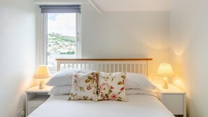 A bedroom with a bed, two bedside lamps, a window with a view, and a white headboard. - 3 Bed in Beer (oc-b31132) (Beer)
