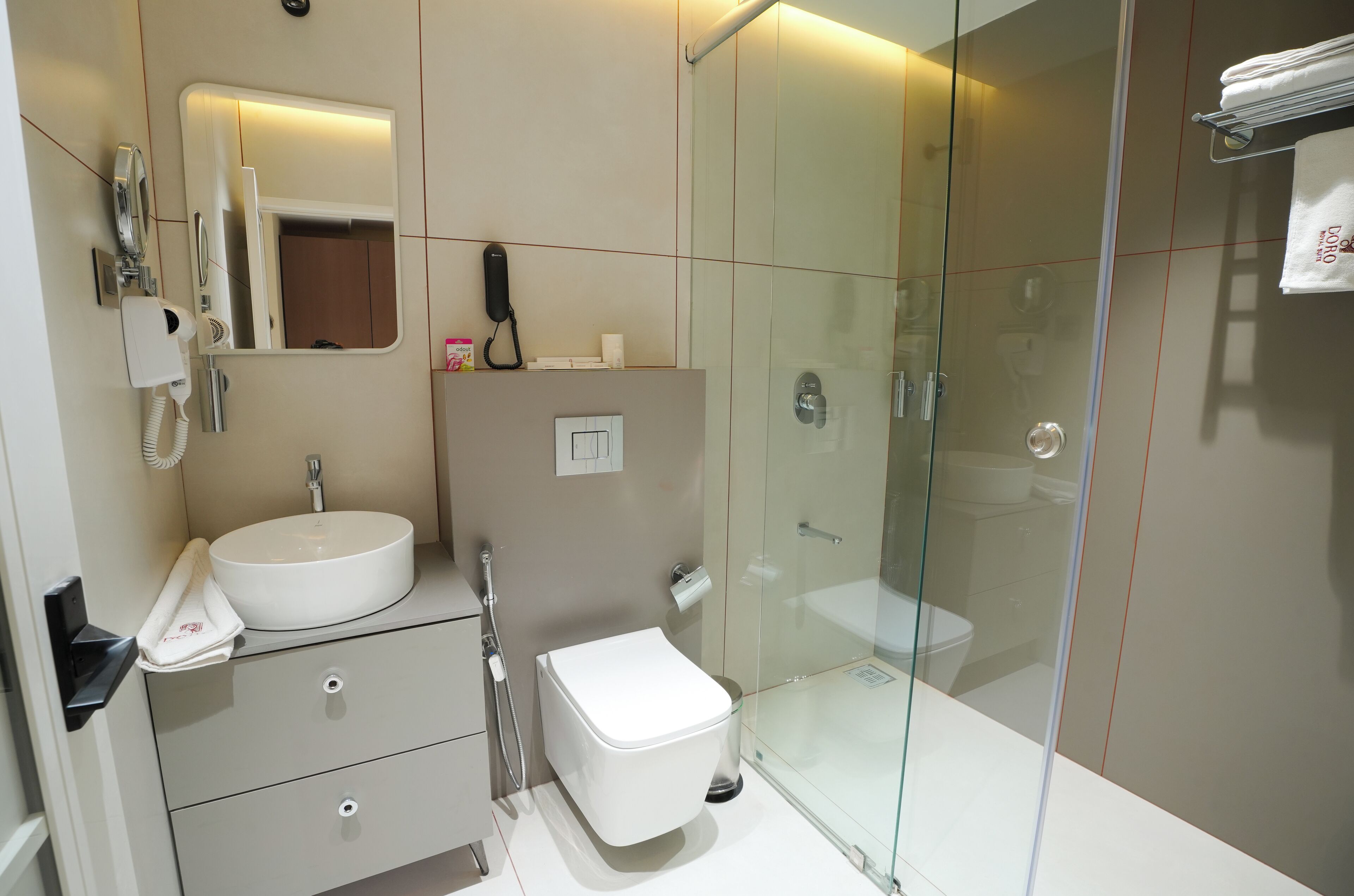 Une salle de bain moderne avec une douche à parois de verre, un lavabo blanc et des toilettes.