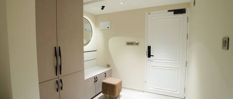 A modern room with a large wardrobe, a small stool, and a door.