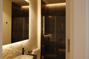 Superior appartement | Badkamer | Een douche, een haardroger, handdoeken, zeep