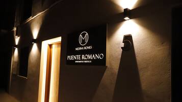 Een bordje voor Medina Homes appartementen Puente Romano, met een logo en de naam.