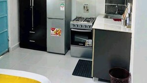 A compact kitchen with a refrigerator, stove, and oven.