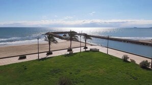 Une vue sur la côte, avec une zone herbeuse, une plage et une étendue d’eau.