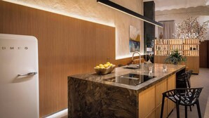 Una cocina moderna con encimera de mármol, lavaplatos integrado y refrigerador.