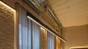 Una cocina moderna con encimera de mármol, iluminación colgante y una pared de acento de piedra.